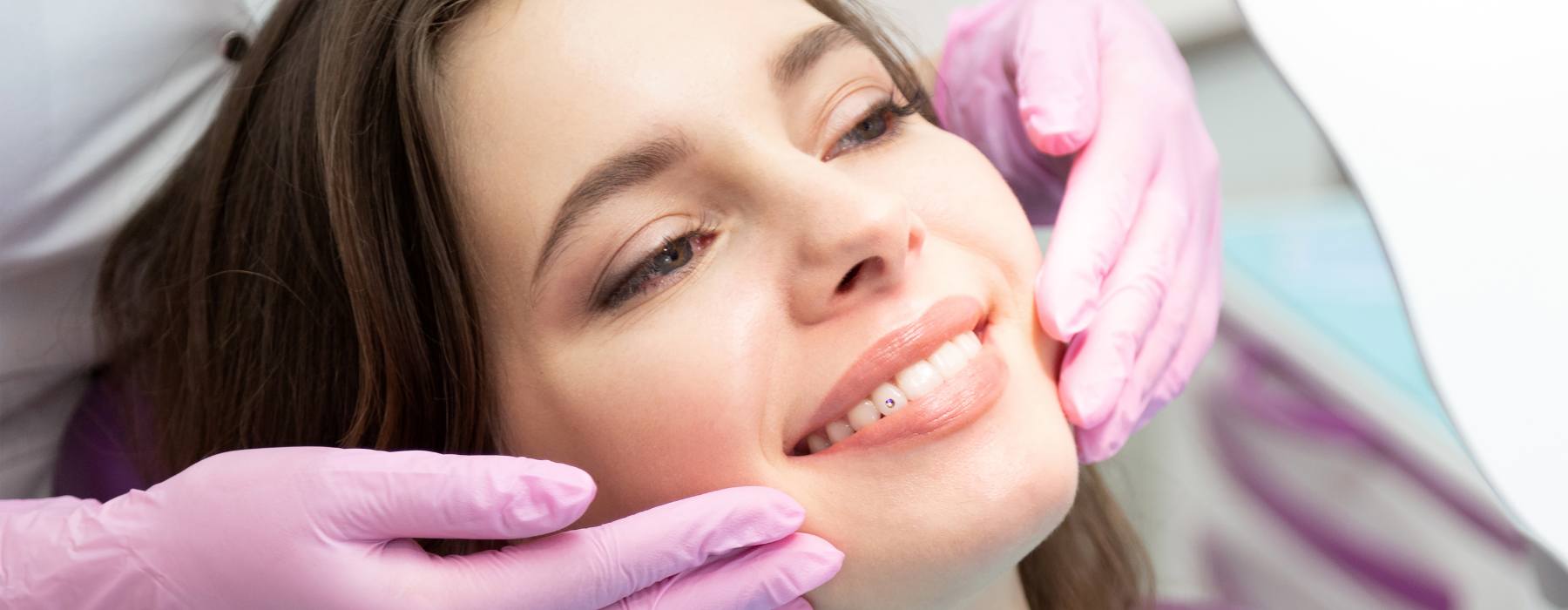 Girl at a dental clinic having a Twinkles tooth gem professionally bonded to her tooth