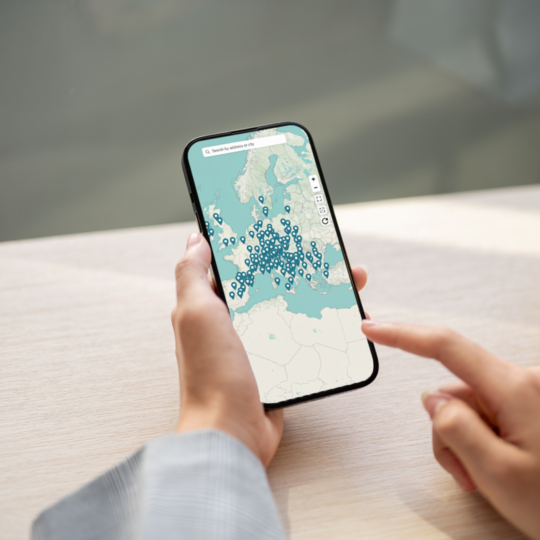 Hands holding a phone showing a map of Europe dotted with Twinkles bonding clinics